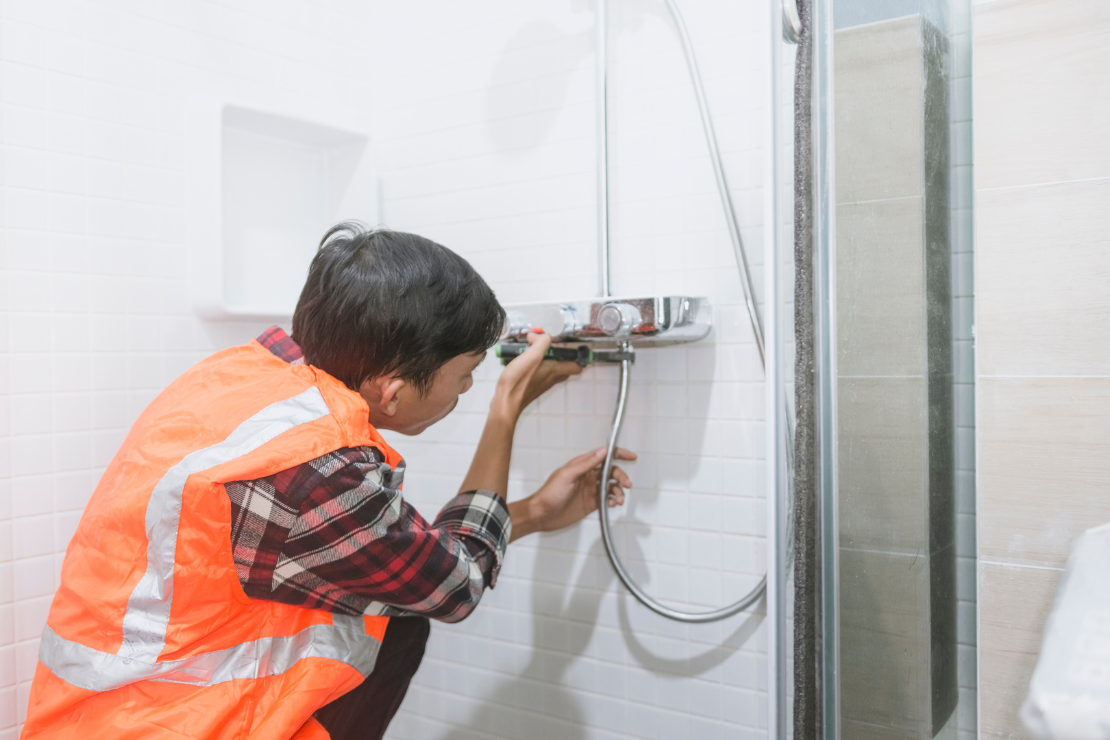 Plumber Installing the Shower in the Bathroom